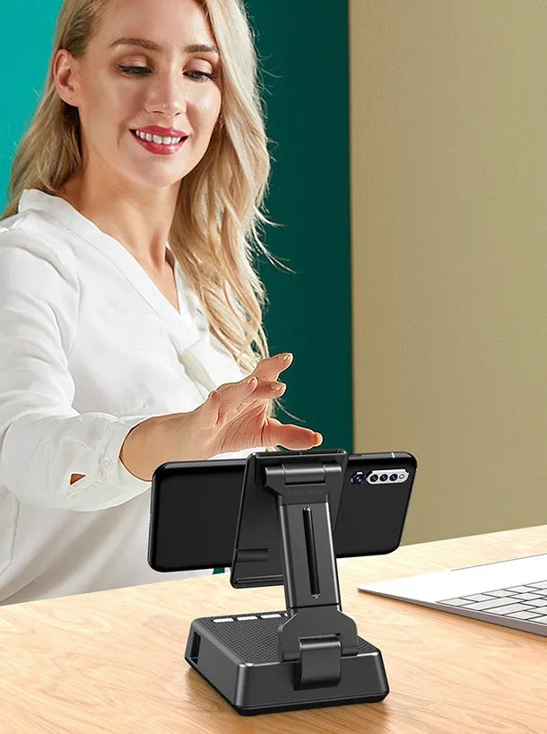 Black mobile phone stand with integrated Bluetooth speaker and microphone on a desk