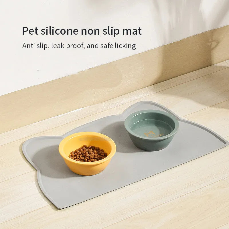 Blue silicone pet feeding mat with cat head shape under dog bowl