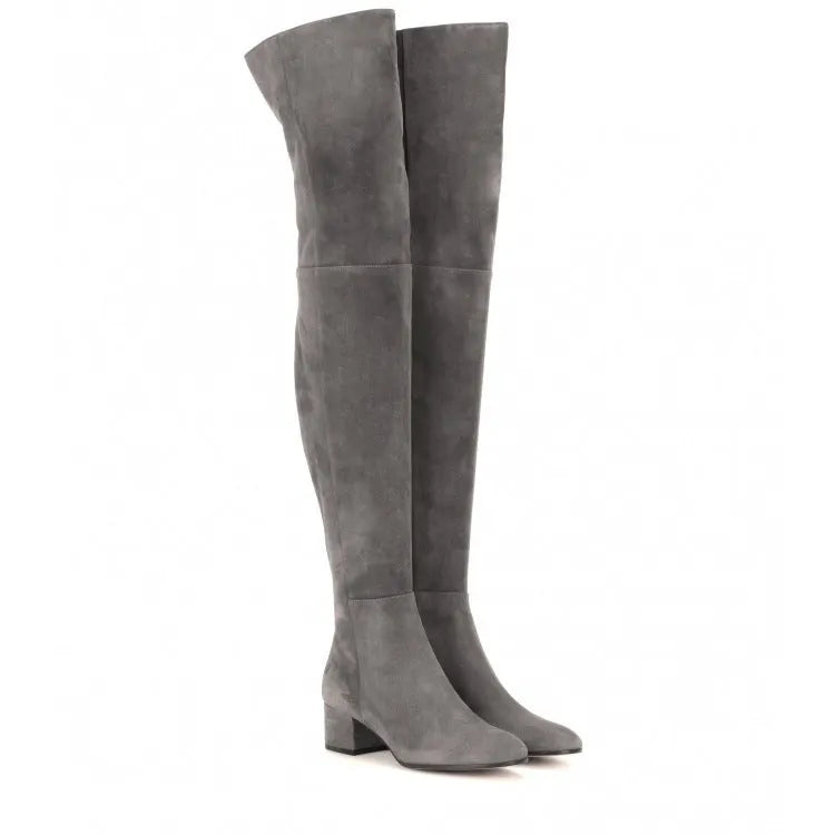 Grey women's suede over-the-knee flat boots with pointed toe and low thick heel on a rubber sole.