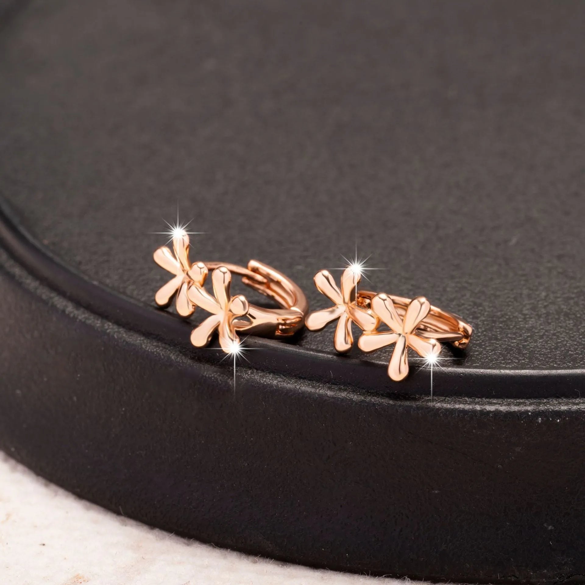 Rose gold coloured circular waterdrop flower earrings with an electroplated finish.