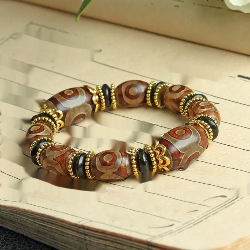 Distressed agate bracelet with traditional Tibetan dzi beads including three-eye and Nine Eyes designs.