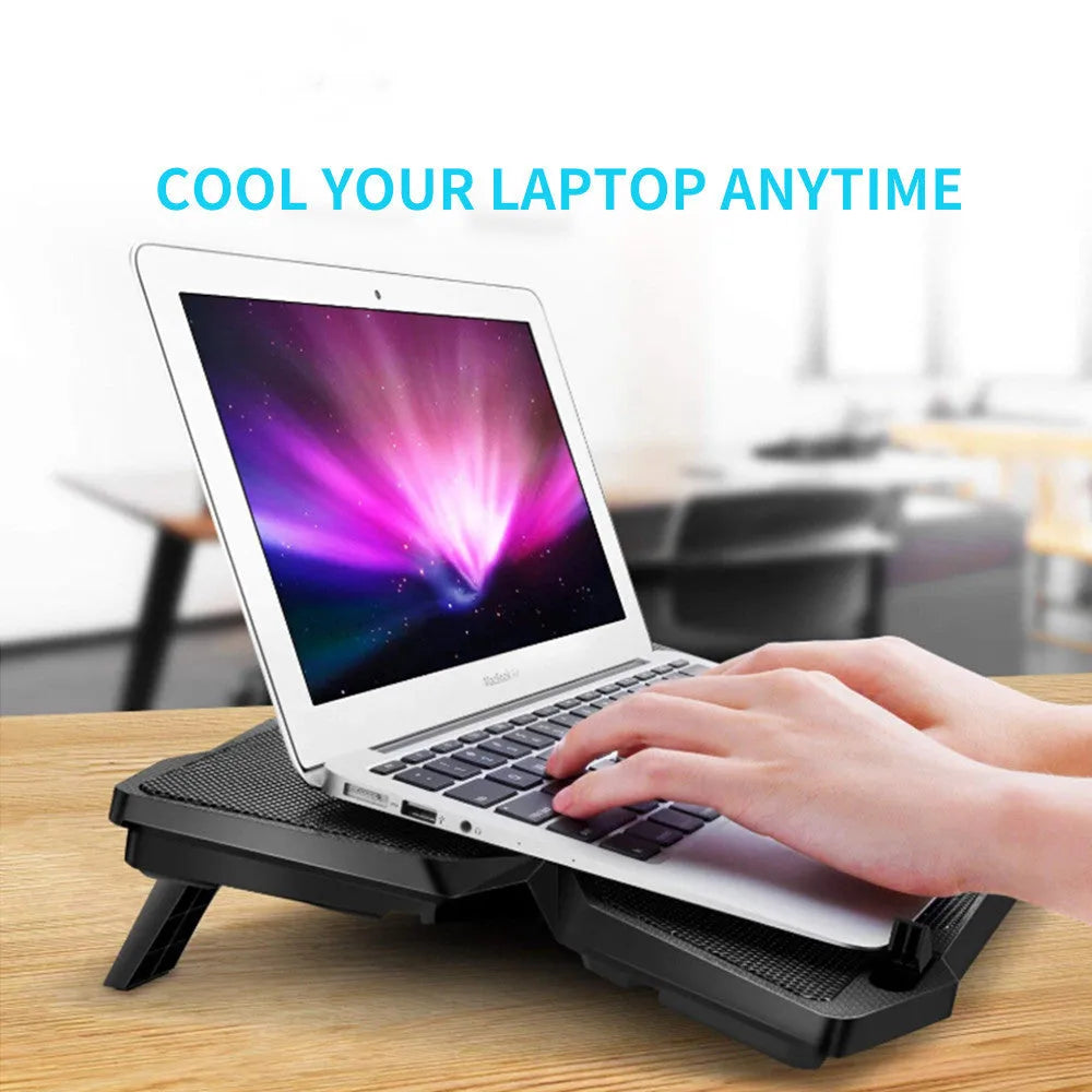 Blue LED computer cooling base with four fans and USB ports on desktop