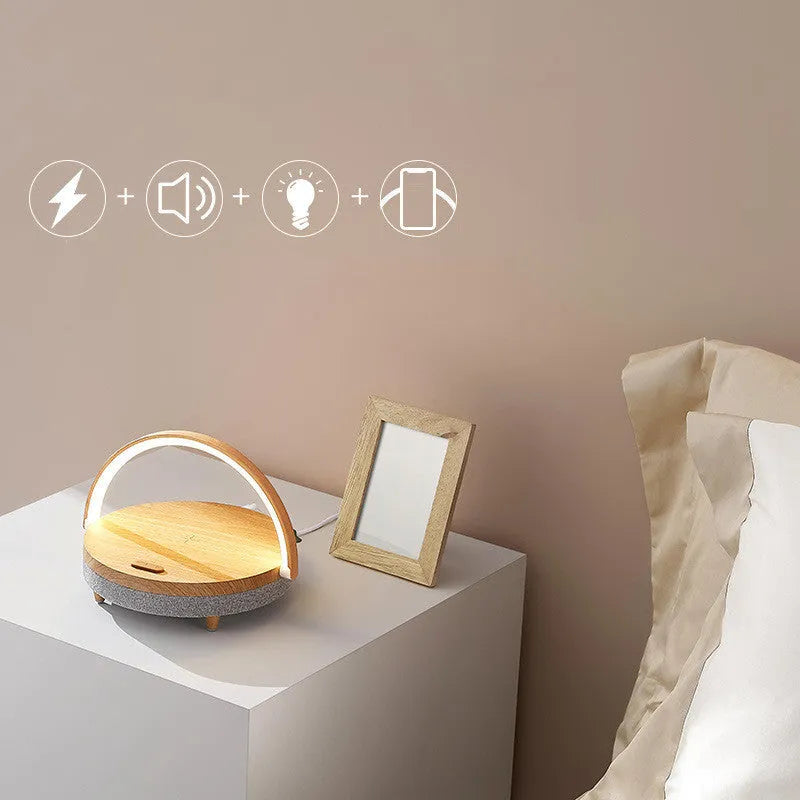 Marble pattern wireless charging desk lamp with integrated Bluetooth speaker and phone holder on a desk.