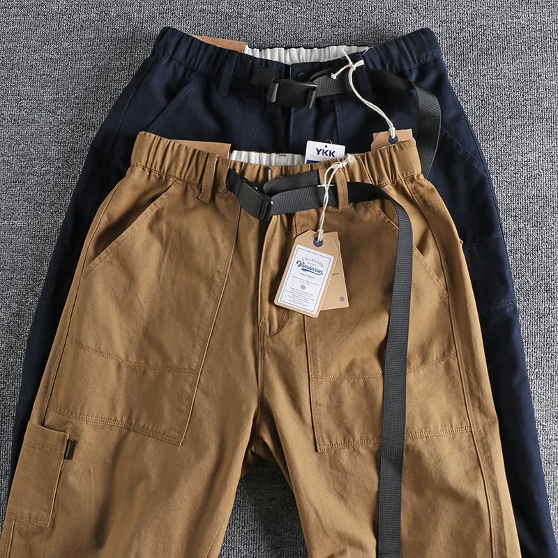 Men's dark blue cotton work trousers with N I buckle belt showing three-dimensional cutting and zip fly fastening