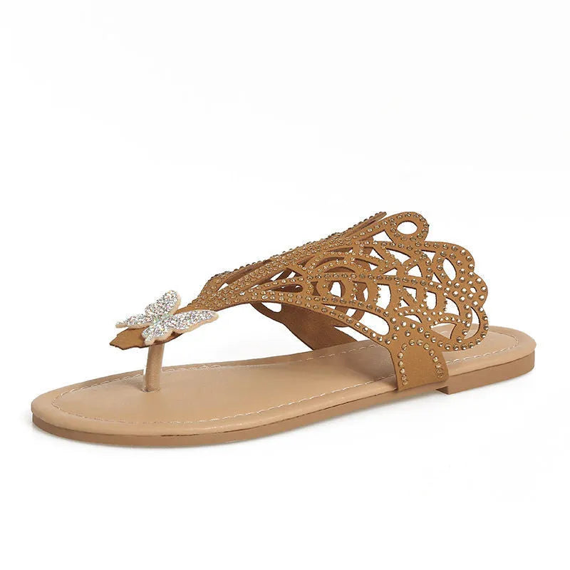 Women's black slip-on sandals with rhinestone detail and a flip-toe design on a flat rubber sole.