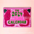 A cat-themed paper wall calendar for 2024 or 2025 displayed flat.