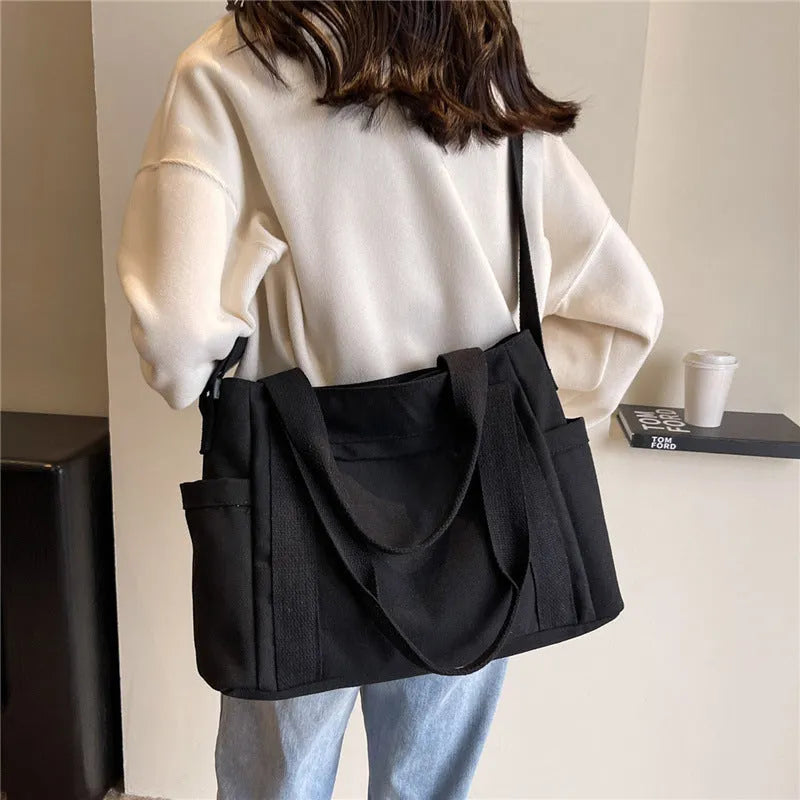 Solid colour polyester tote bag with large capacity and a mobile phone pocket.