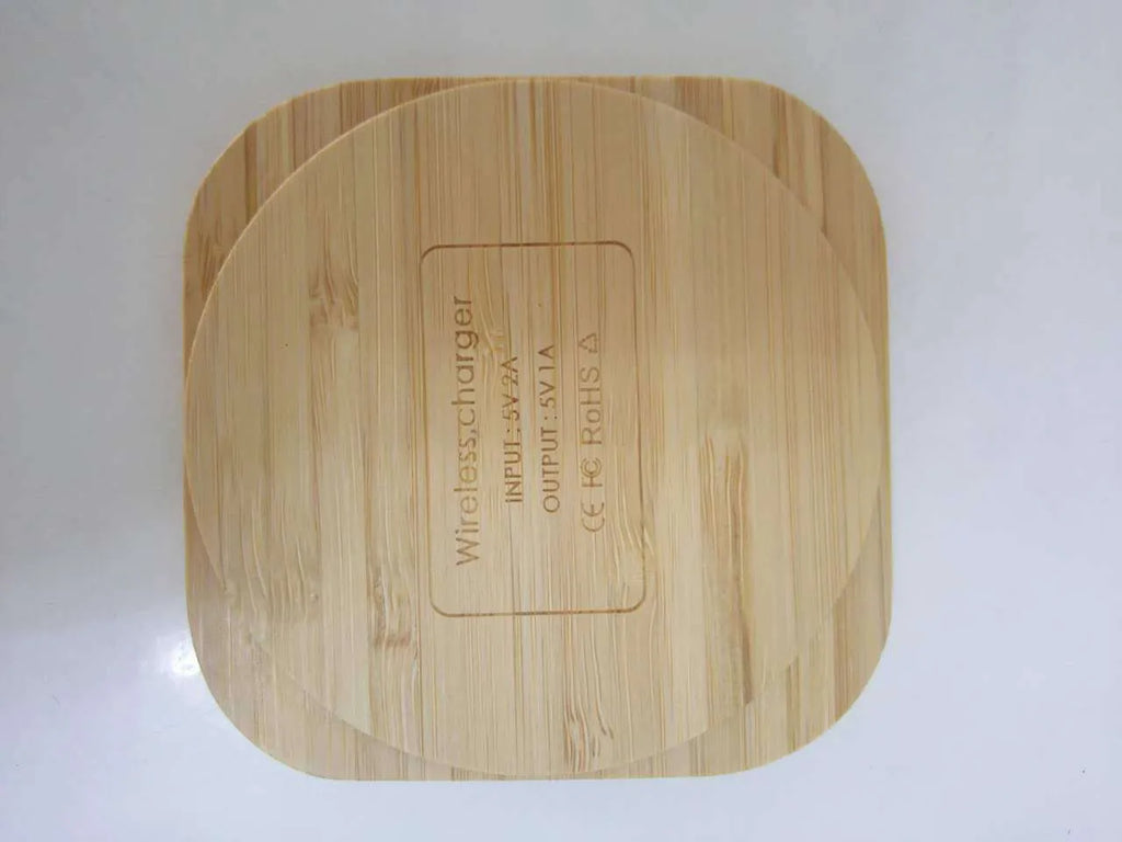 Square brown wooden bamboo 5W Qi wireless charging pad on a table.