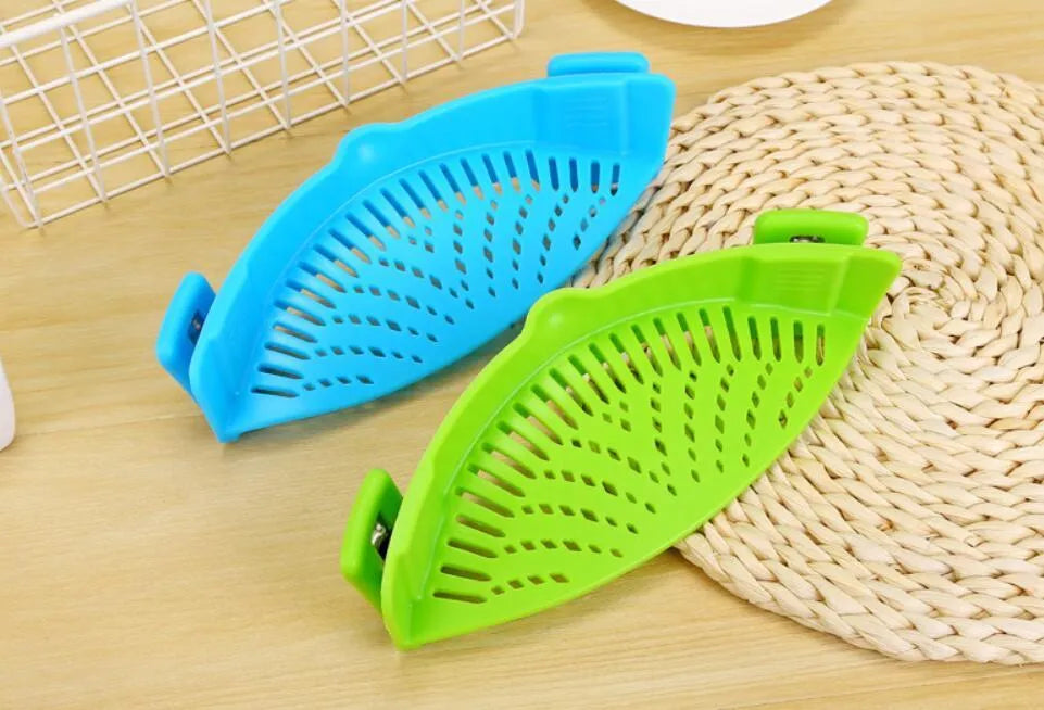 Silicone clip-on funnel strainer attached to kitchen pot for draining liquids