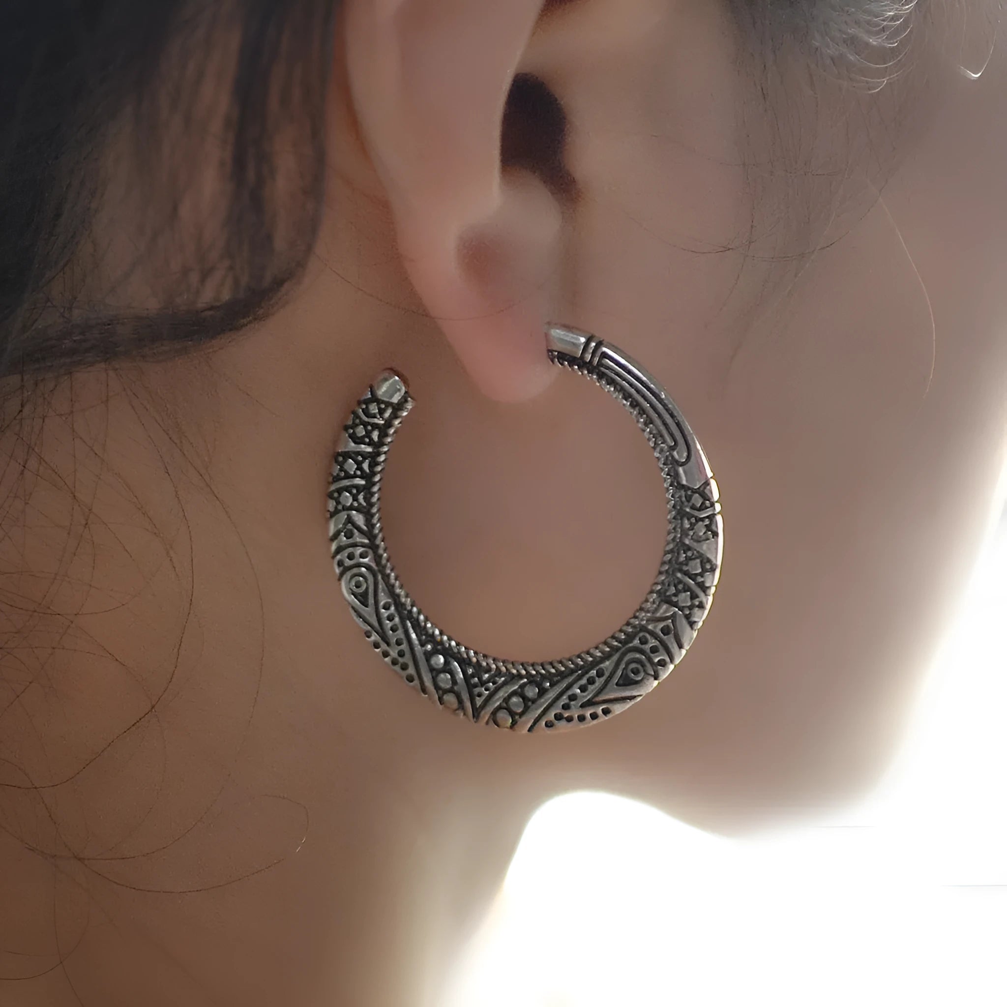 C-shaped alloy earrings with vintage engraving pattern in bronze colour showing curved design and butterfly clasp