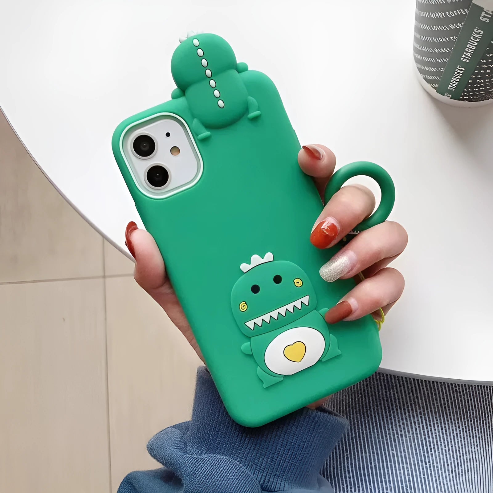 Green silicone iPhone case with cartoon animal design showing drop and waterproof protection features