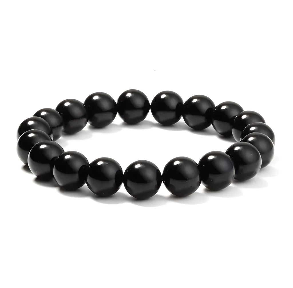 Close-up of a women's black onyx bracelet with 8mm geometric agate beads on a black elastic cord.