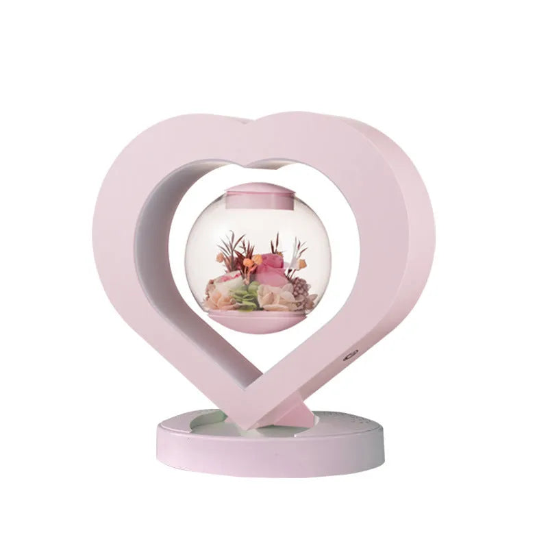 Pink preserved rose ornament with LED lights on a base with audio Bluetooth connectivity.