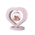 Pink preserved rose ornament with LED lights on a base with audio Bluetooth connectivity.