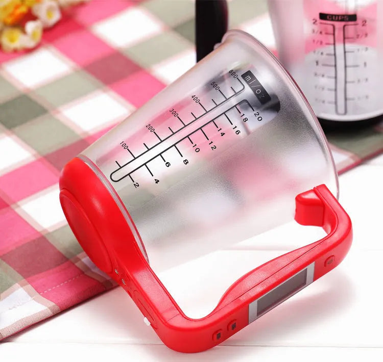 Green digital kitchen measuring cup with integrated LCD display showing weight and temperature measurements