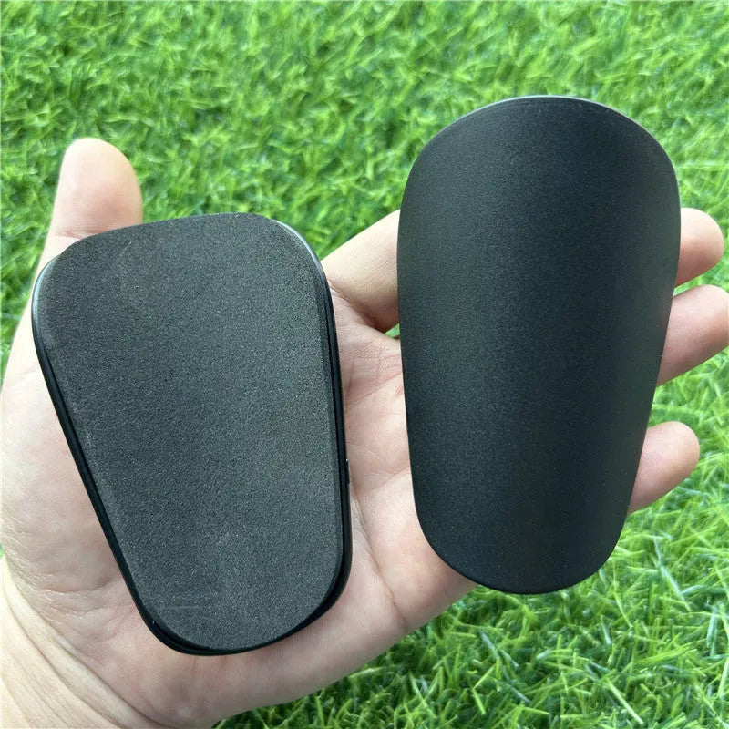 Extra small mini football shin guards in black and white colours showing 8x5cm plastic construction