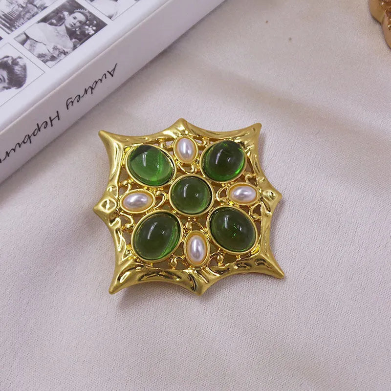 Classic vintage zinc alloy brooch with baroque-style cross design and crystal details on a dark background.