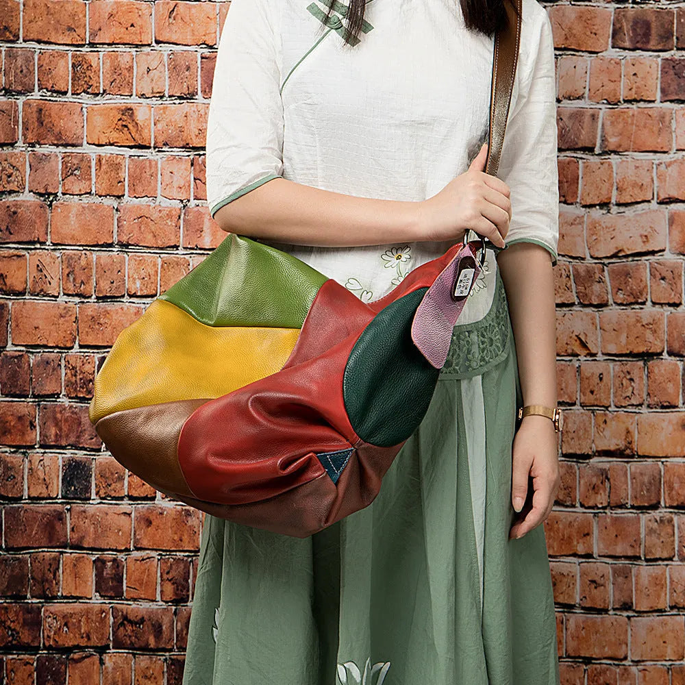 Brown cowhide leather crossbody bag with stitching rubbing texture, shown holding a laptop and A4 magazine.