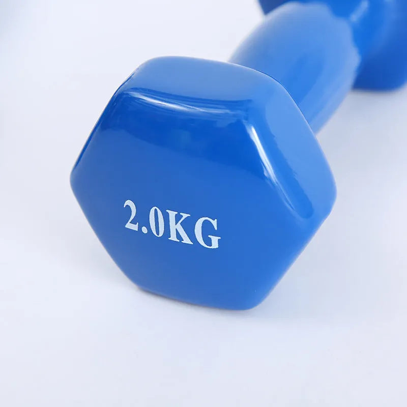 Set of bright green and purple plastic dumbbells on a wooden floor.