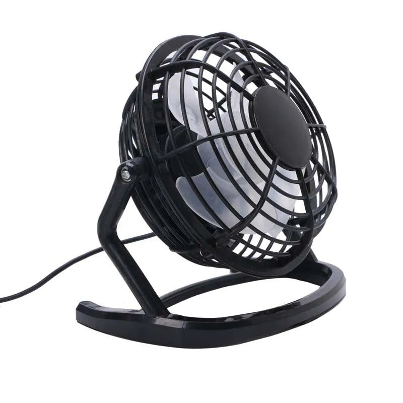 Mini black USB desk fan with adjustable angle on wooden desk next to laptop