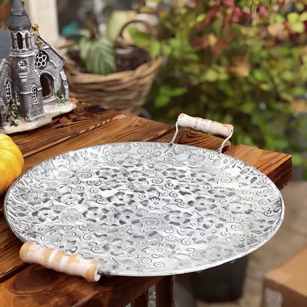 Round European wrought iron belt storage tray in two size options on a wooden surface.