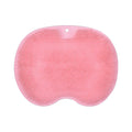 Orange silicone bristle massage bath brush with suction cup bottom on bathroom floor