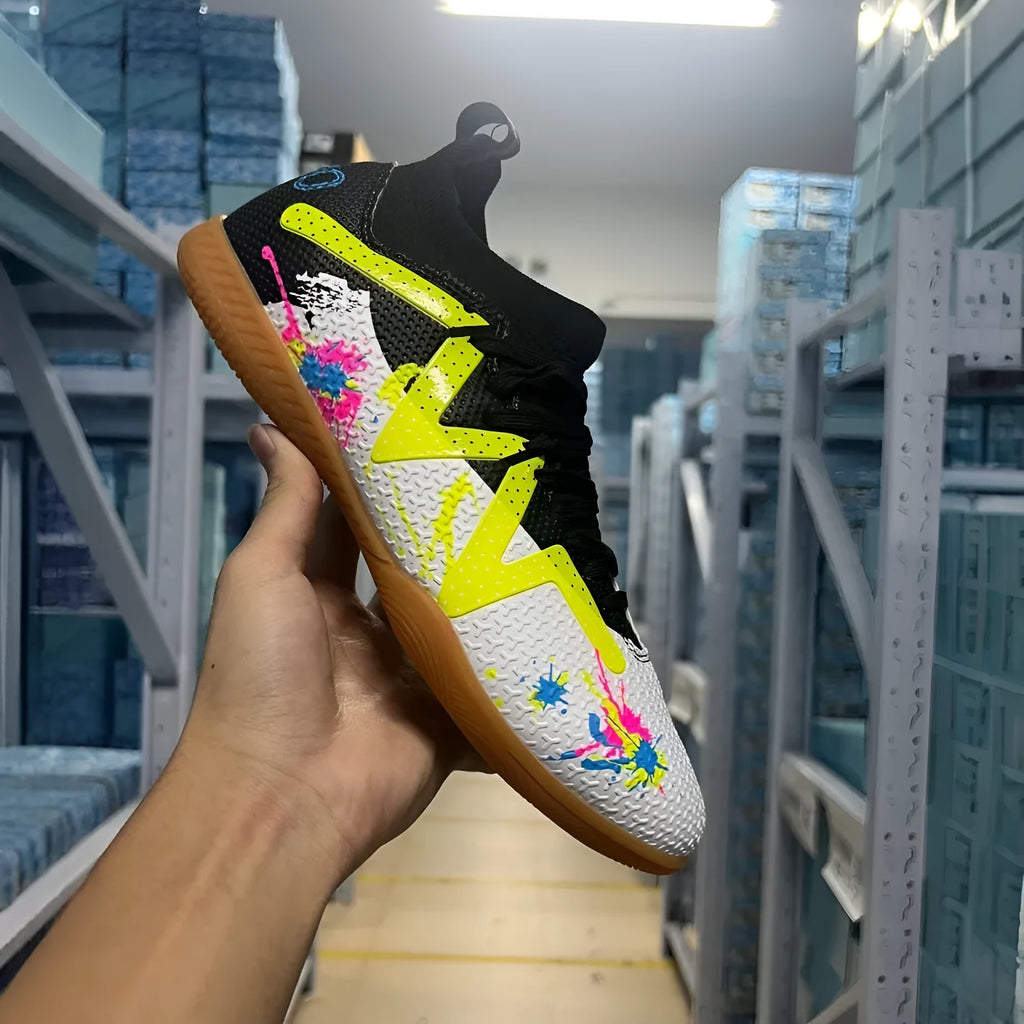 Low-top men's football boots in black and yellow with a PVC upper and rubber studded outsole.