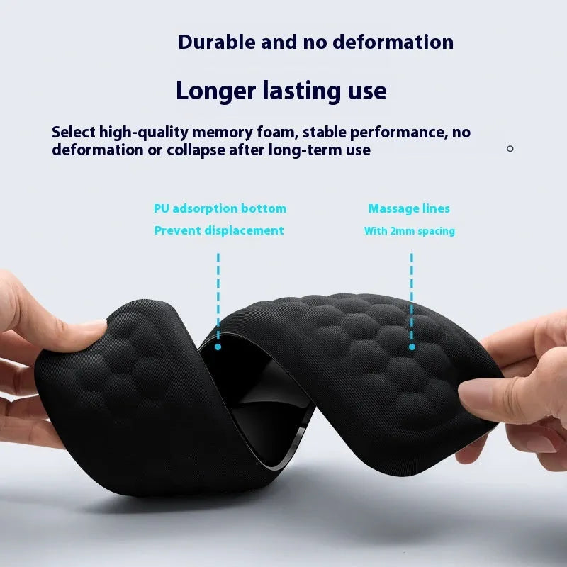 Black memory foam mouse wrist pad with a leather-style cover on a wooden desk