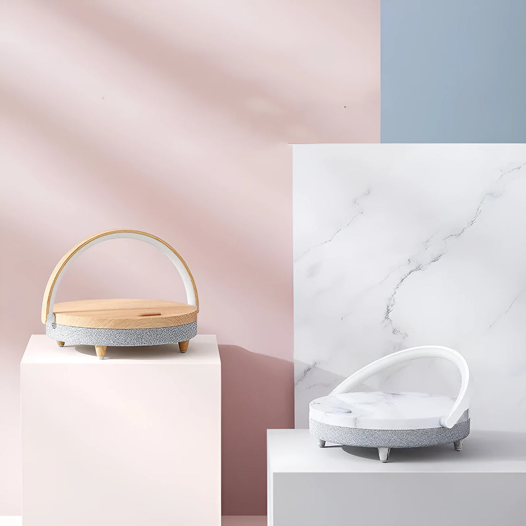 Marble pattern wireless charging desk lamp with integrated Bluetooth speaker and phone holder on a desk.