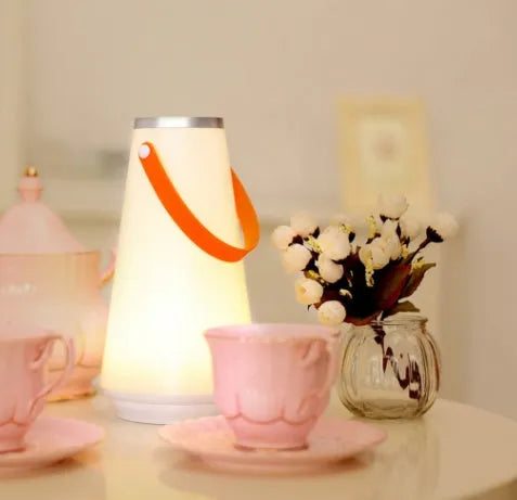 White rechargeable LED bedside lamp with square base measuring 12cm, showing warm white illumination from six LED beads