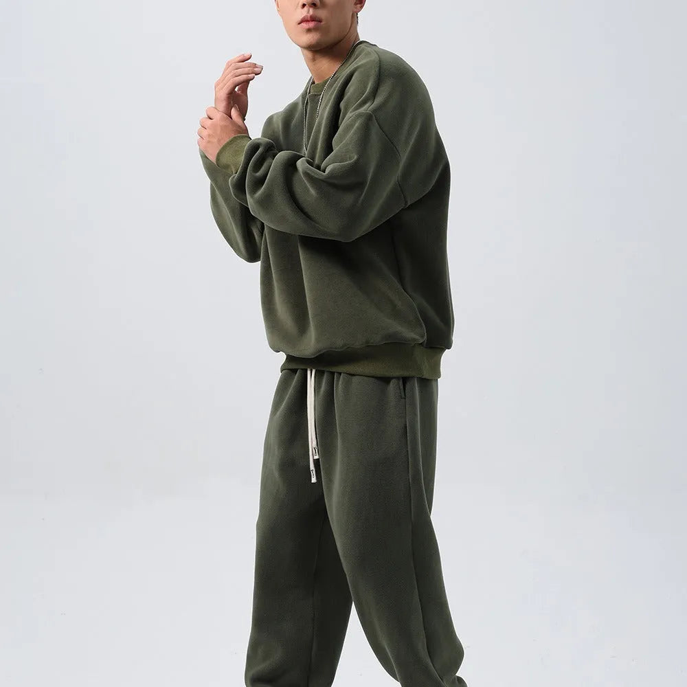 Men's black polar fleece sports suit with crew neck coat and matching trousers on a hanger.