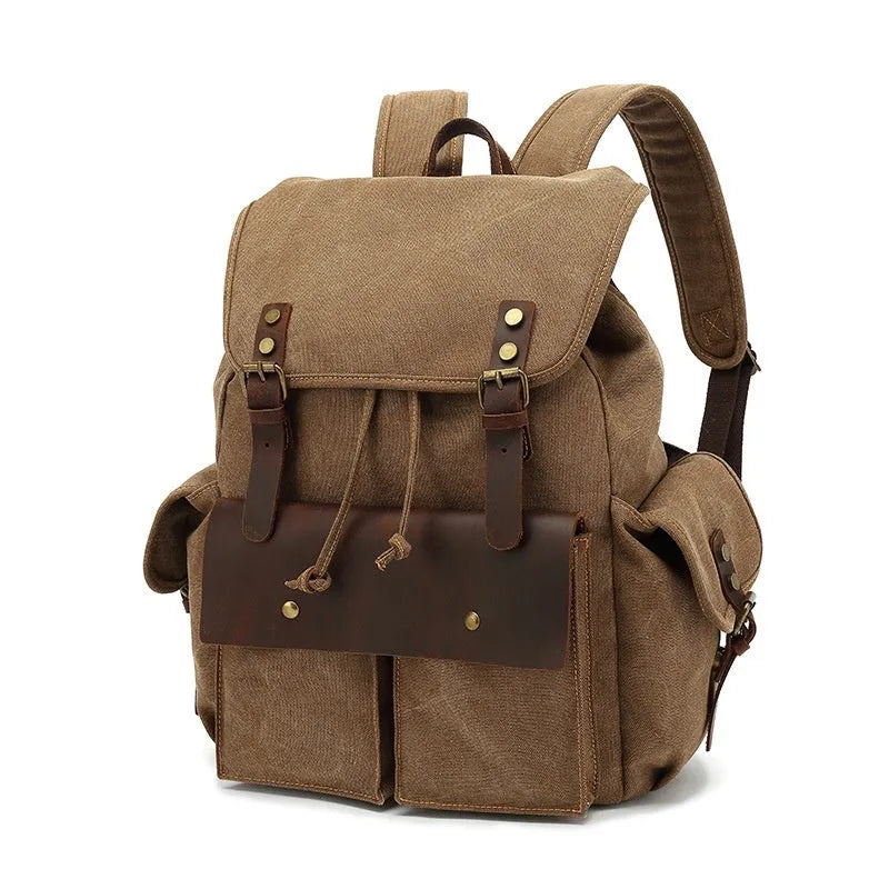 Retro canvas backpack in military green with antique bronze hardware, shown next to a 16-inch laptop.