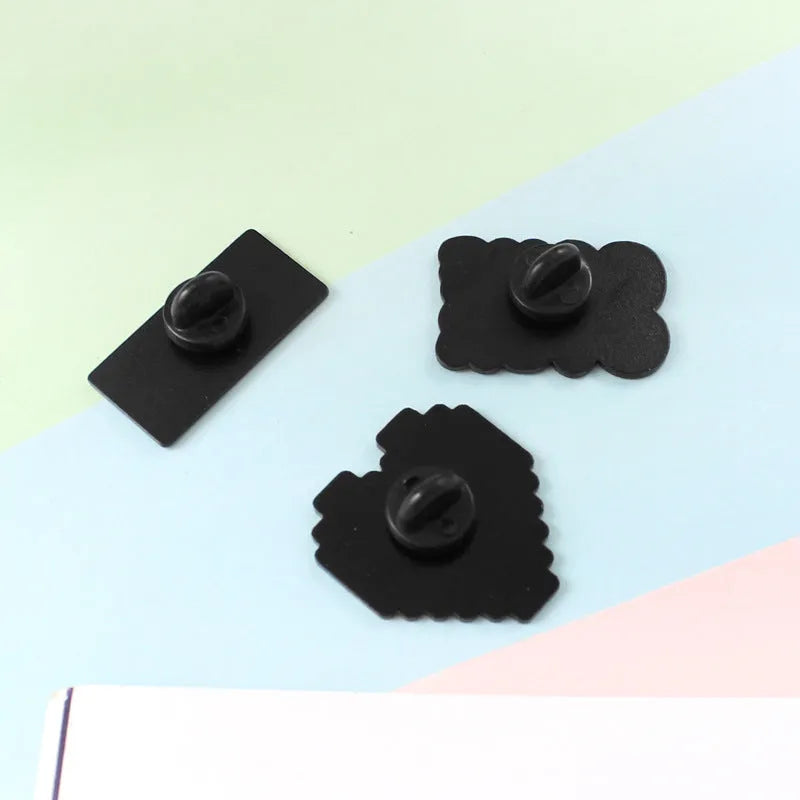 Stereo game console design metal badge with pin back, shown in one of three alloy colour options.