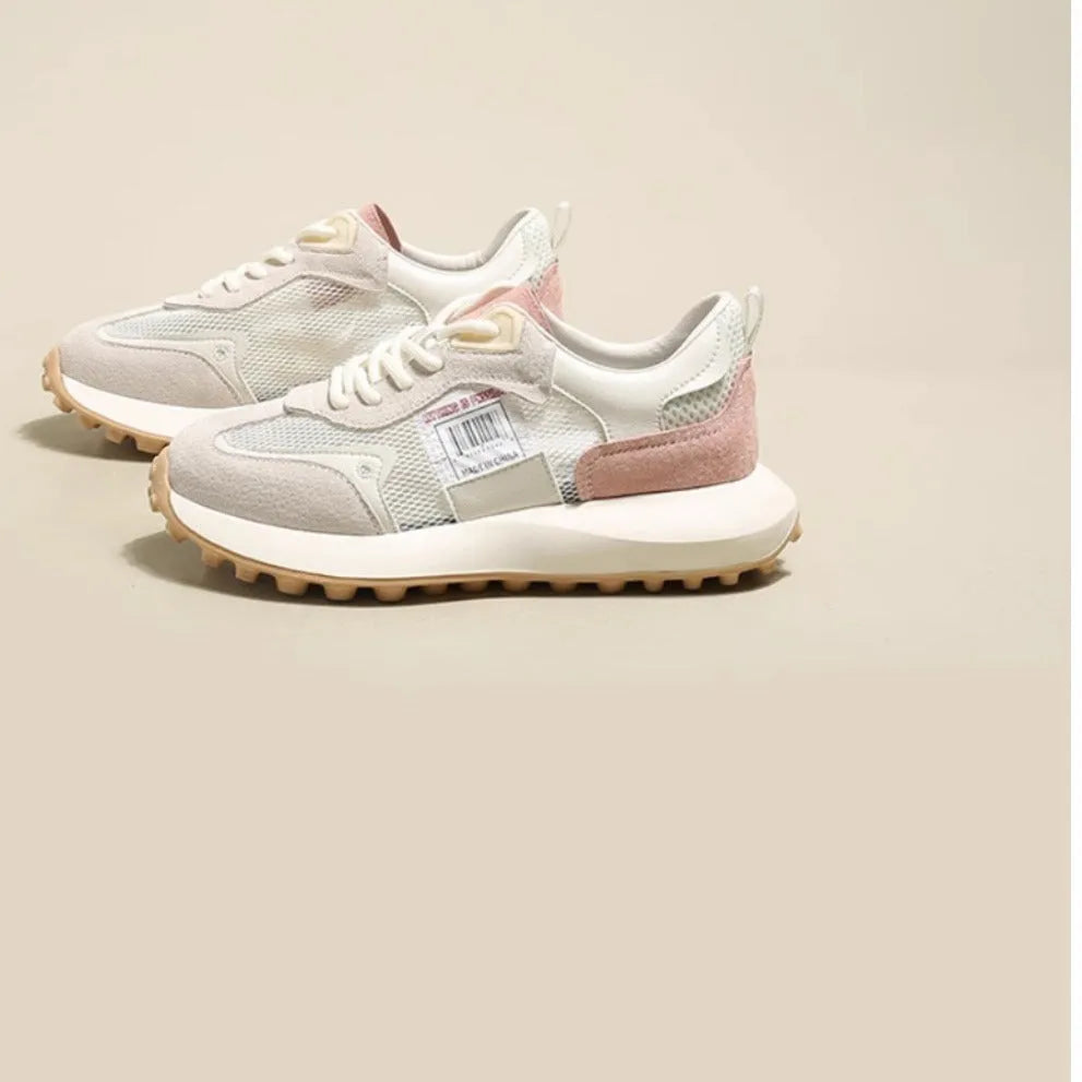 Grey and pink women's low-top retro sneaker with round toe and rubber sole on a white background.