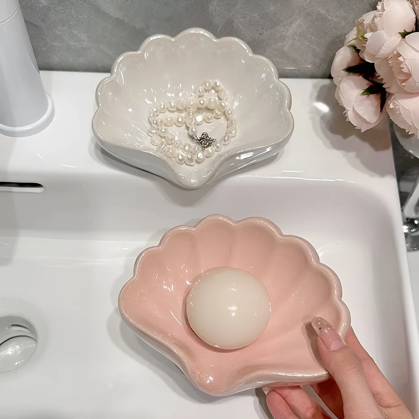 Shell-shaped white plastic soap dish with raised base for bathroom use
