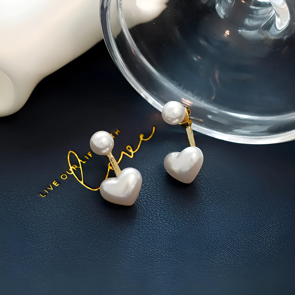 Women's silver-toned heart-shaped stud earrings with central gemstone inlay on a white background.