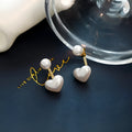 Women's silver-toned heart-shaped stud earrings with central gemstone inlay on a white background.