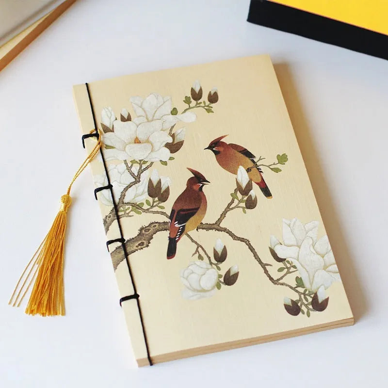 A5 antique wire-bound notebook with glossy embossed cover featuring a retro painting design, shown open.