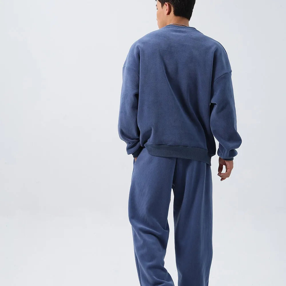 Men's black polar fleece sports suit with crew neck coat and matching trousers on a hanger.