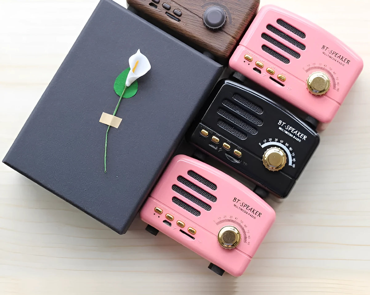 Vintage wood Bluetooth speaker in black, pink and wood grain colours showing compact design