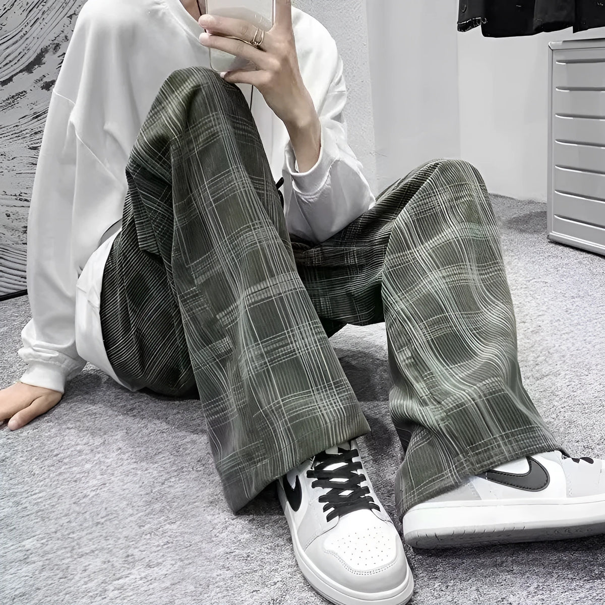 Man wearing black plaid retro loose-fit straight-leg casual trousers.