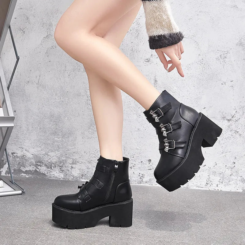 Black women's punk style short boots with bat buckle, thick heel, and side zipper.