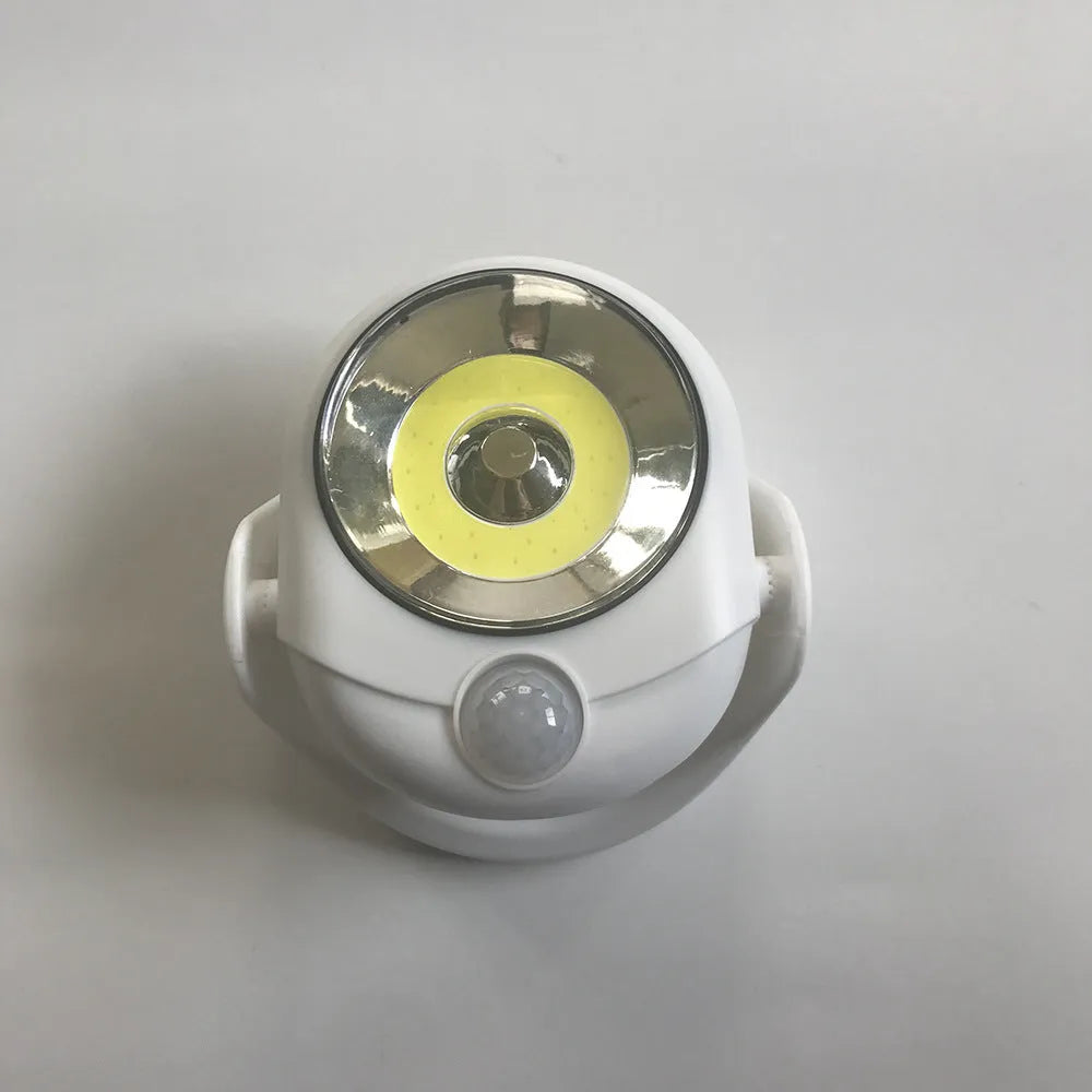 White Atomic Angel induction LED night light with touch sensor on front.