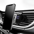 Black car phone holder mounted on car air vent with phone in adjustable clamp