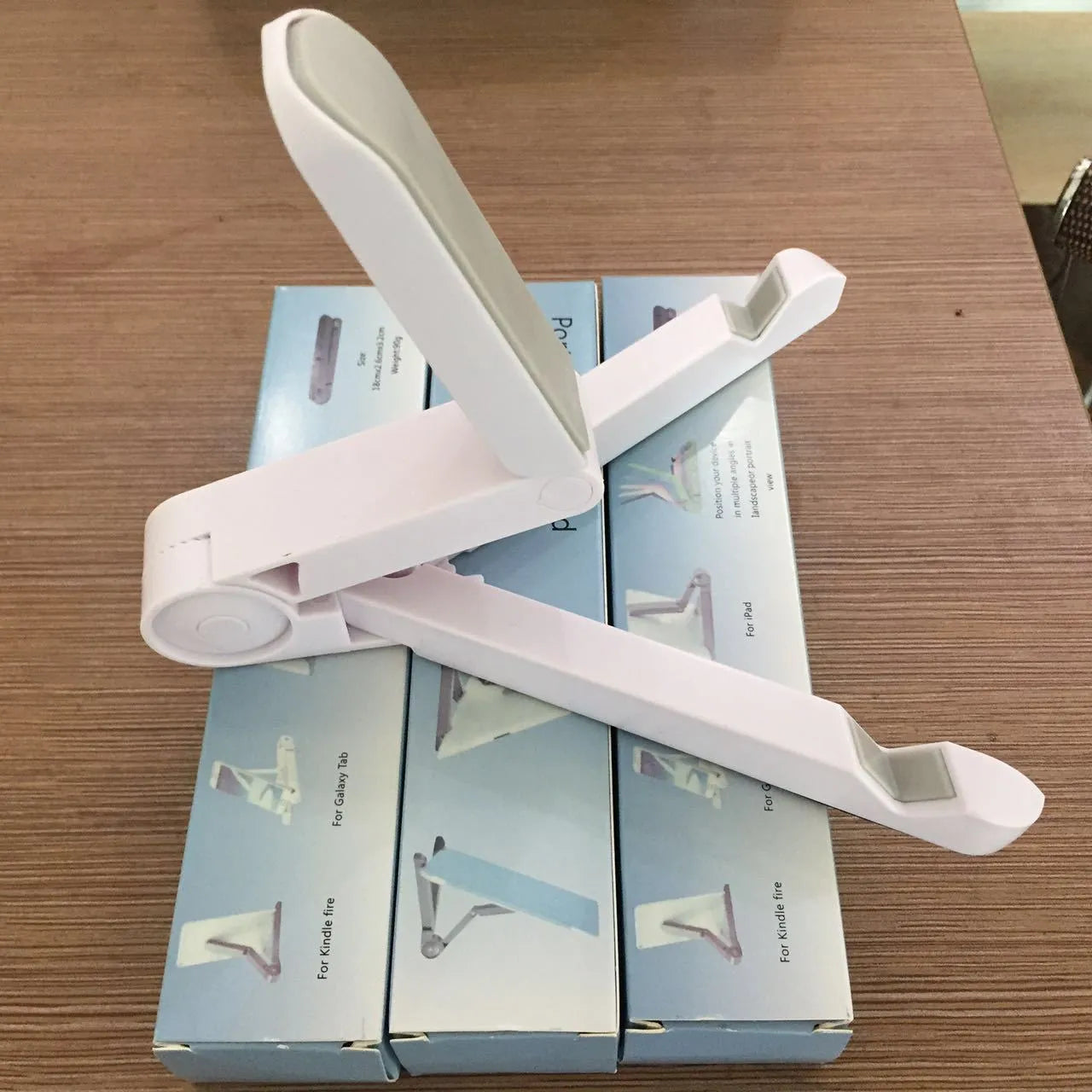 Black foldable aluminium tablet holder showing adjustable angles and flat-folded profile