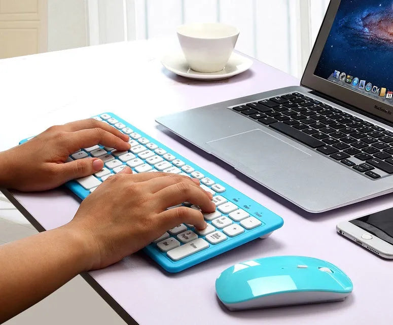 Black wireless keyboard and mouse set with compact 96-key layout and USB receiver on a wooden desk.