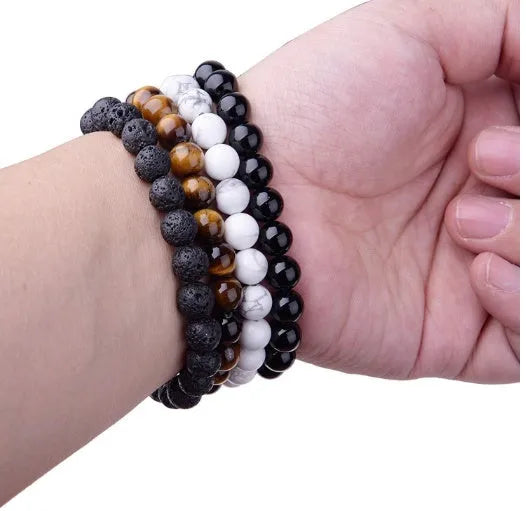 Close-up of a women's black onyx bracelet with 8mm geometric agate beads on a black elastic cord.