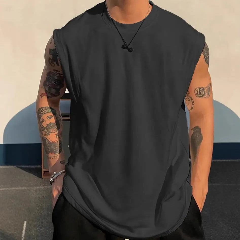Man wearing a loose apricot-coloured cotton tank top, showing the sleeveless design and straight hem.
