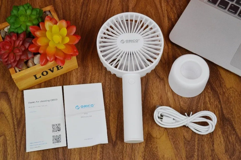 White ORICO FH1 portable USB desk fan with fine-line texture, shown as a handheld and desktop unit.