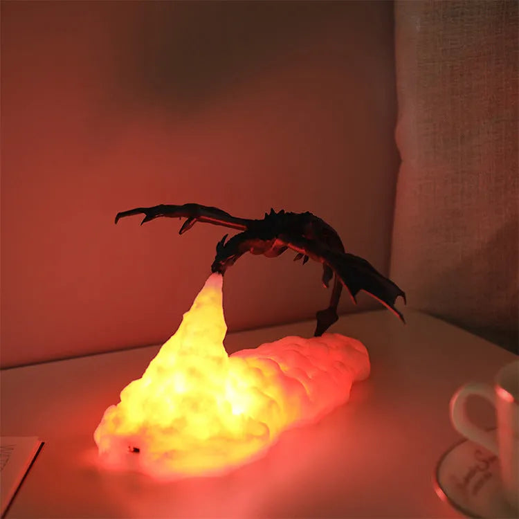3D printed red dragon night light glowing on a table next to its USB charging cable.